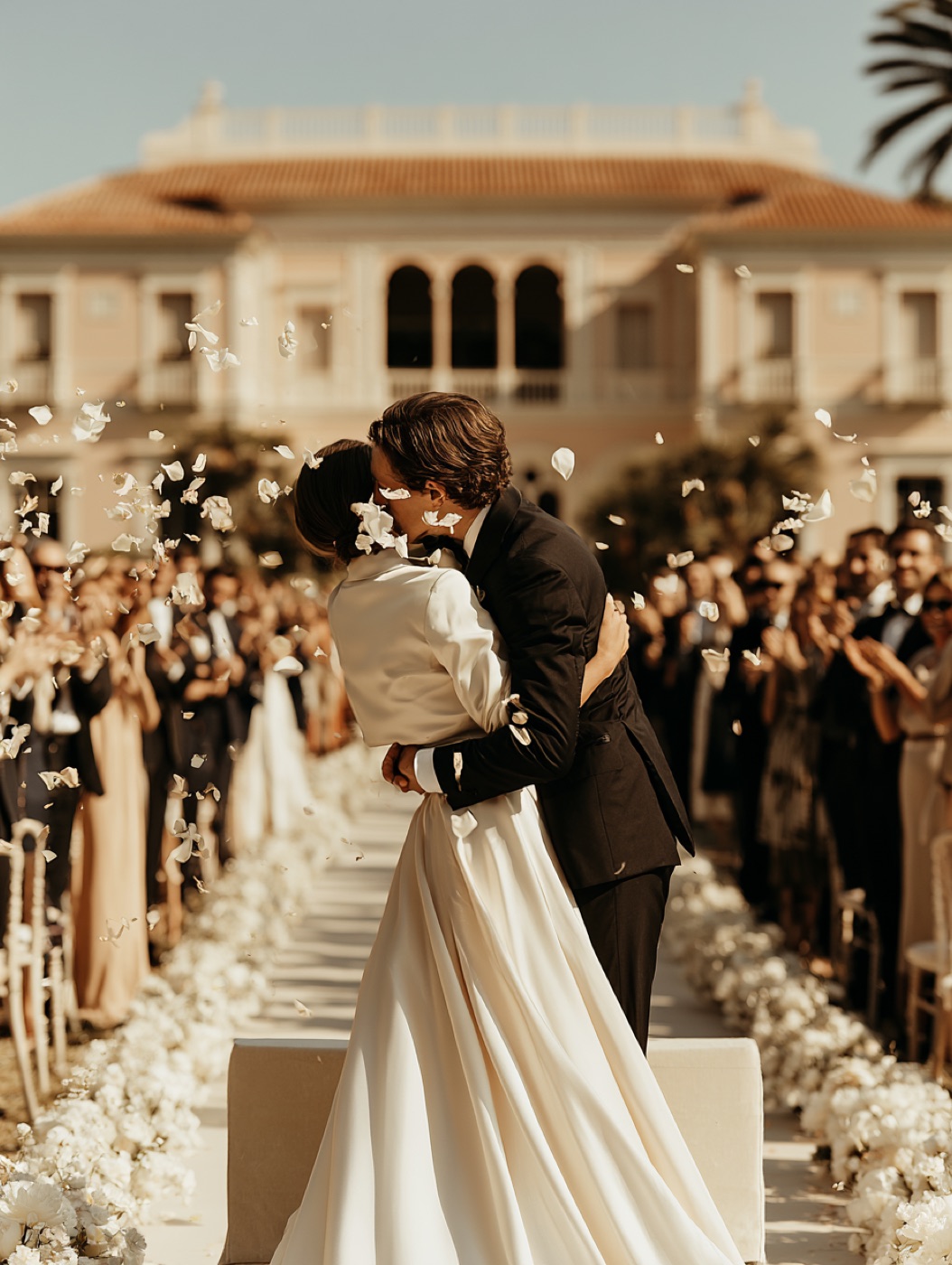 The couple kissing beneath flower petals